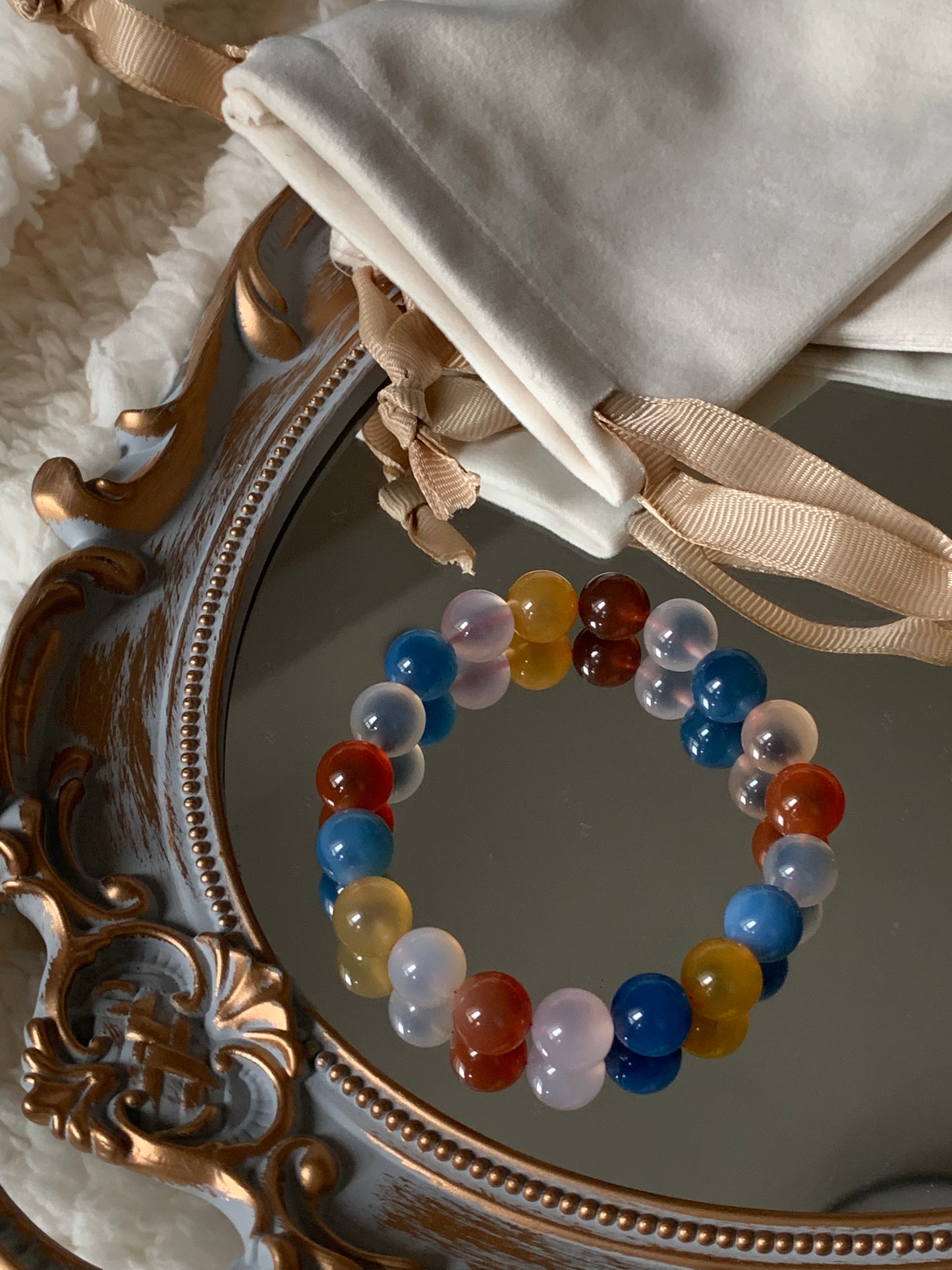 Close up of sugar agate bracelet on the top of an elegant mirror.